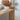 Autumn home styling with burnt orange eucalyptus, ceramic pumpkins and rattan tray on a wooden console table